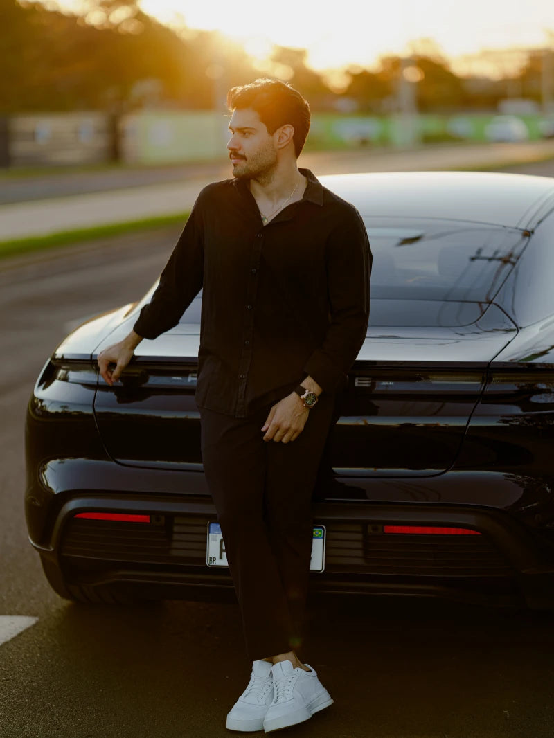 Homem encostado em carro esportivo ao pôr do sol usando relógio automático masculino CURTT — acessório de estilo masculino