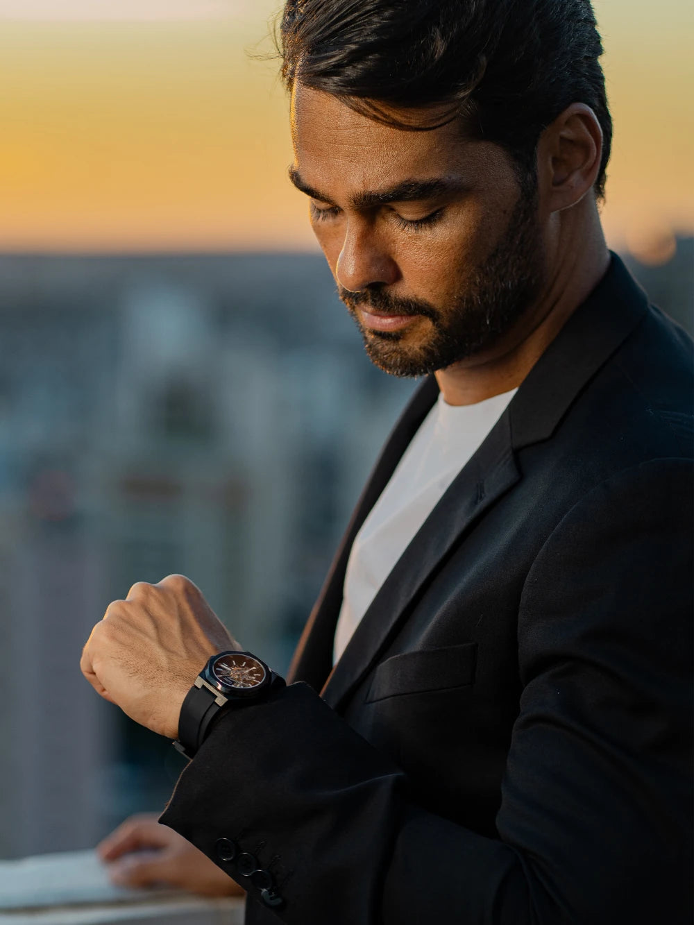 Homem de terno conferindo as horas no relógio automático masculino CURTT ao entardecer — acessório de moda masculina